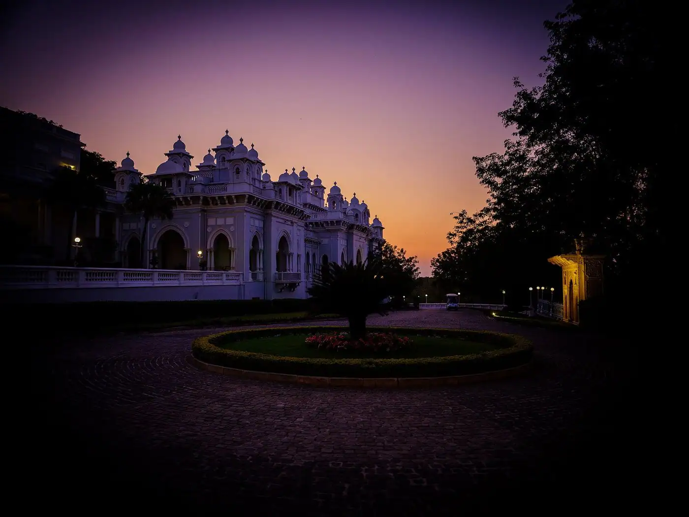 A white palace silhouetted against a violet dusk sky